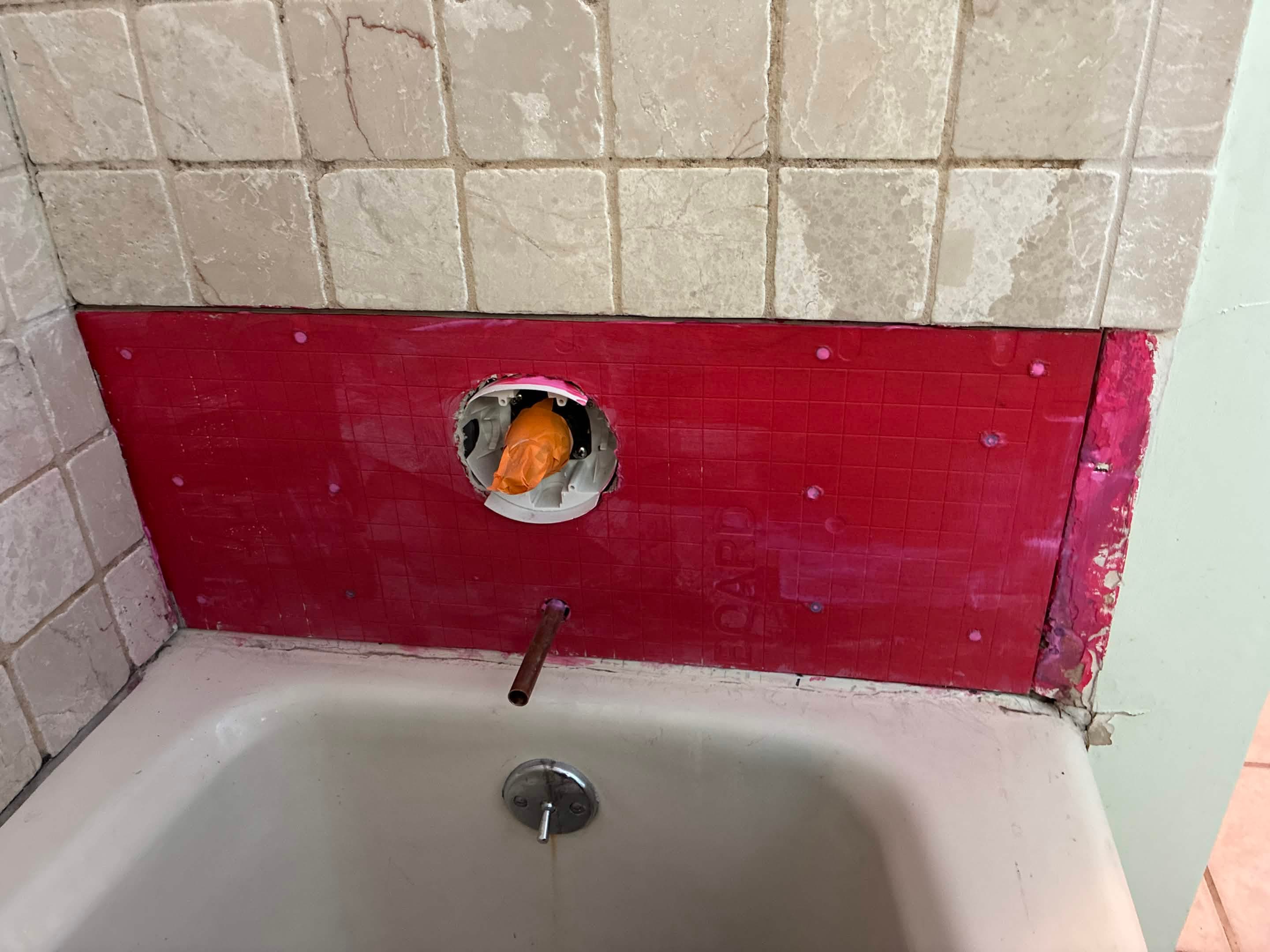RedGard waterproofing membrane applied over tub surround before tile