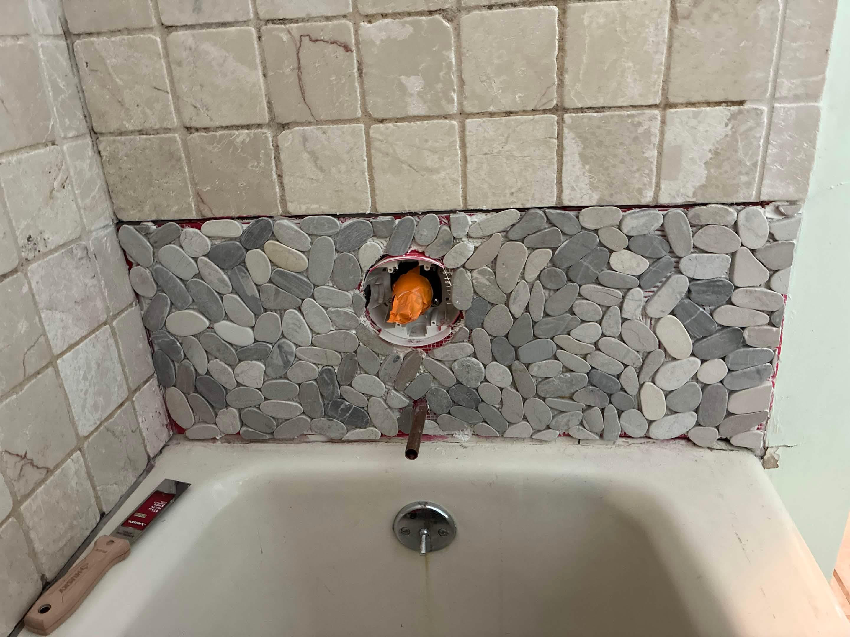 Pebble mosaic accent band set, tape removed, ready for grouting