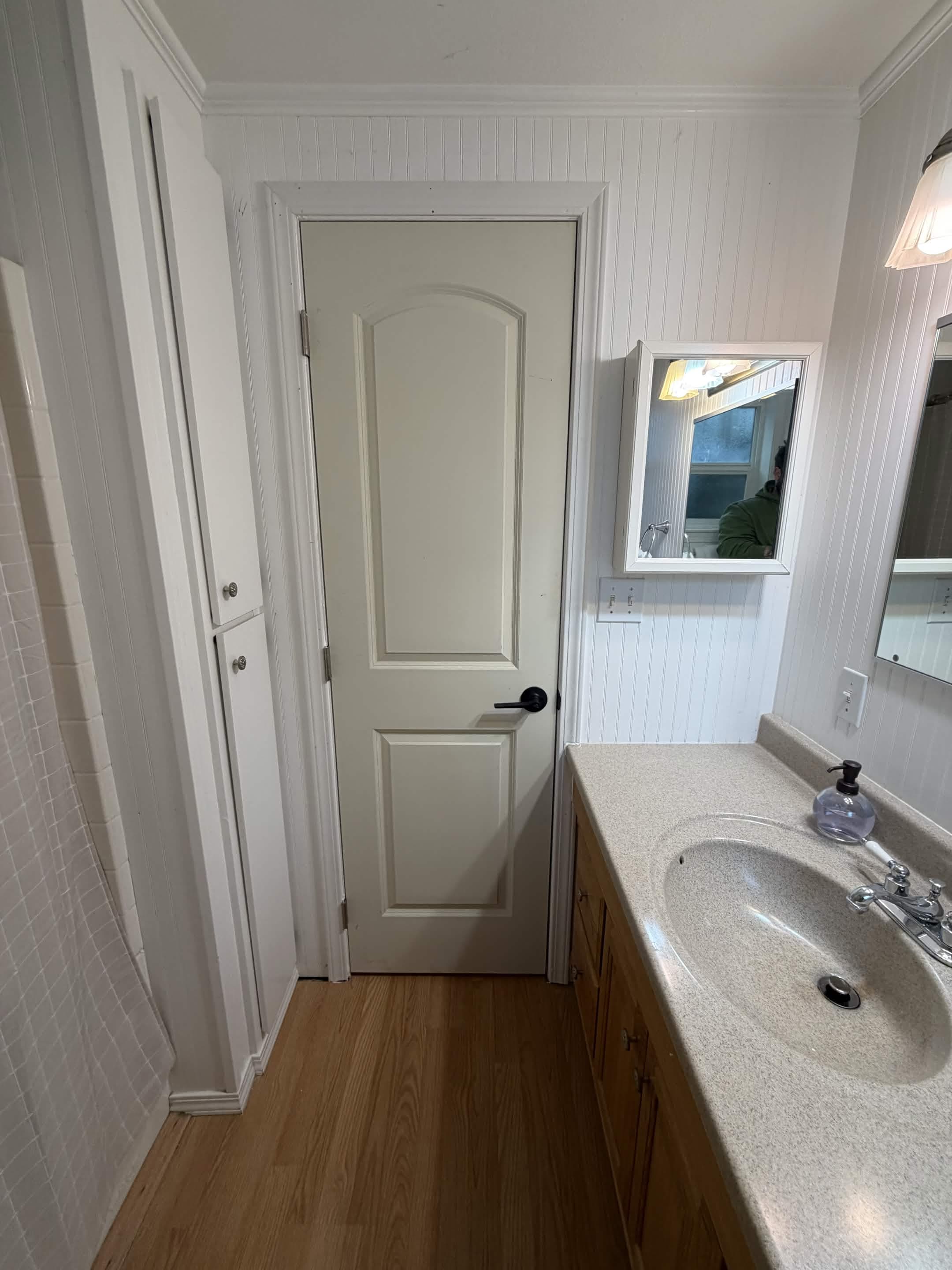 Bathroom remodel with new interior door, vanity, and trim work by Sourdough Construction in Juneau